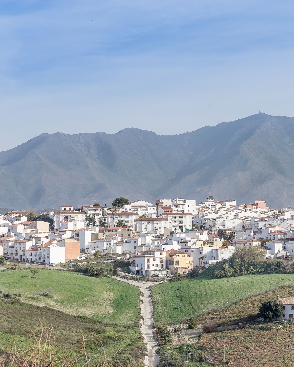 Manilva village, white houses on a hillside with the mountains behind.